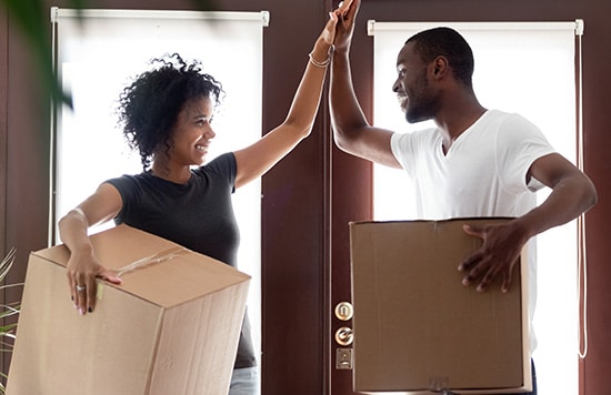 couple giving each other a high five after successfully moving out 5 Hacks to Help Earn Soaring Airline Miles—And Travel Points!
