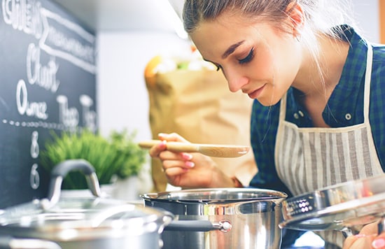 person learning how to cook 5 Hacks to Help Earn Soaring Airline Miles—And Travel Points!