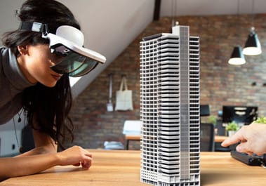 Une femme d’affaires qui porte un casque de réalité virtuelle regarde la maquette d’un édifice