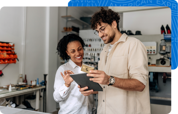 Two small business owners using their tablet at their shoe repair workshop to look up their rate.
