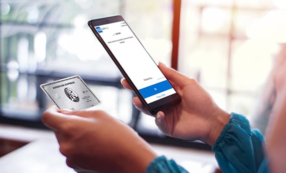 Person holding phone and Amex credit card