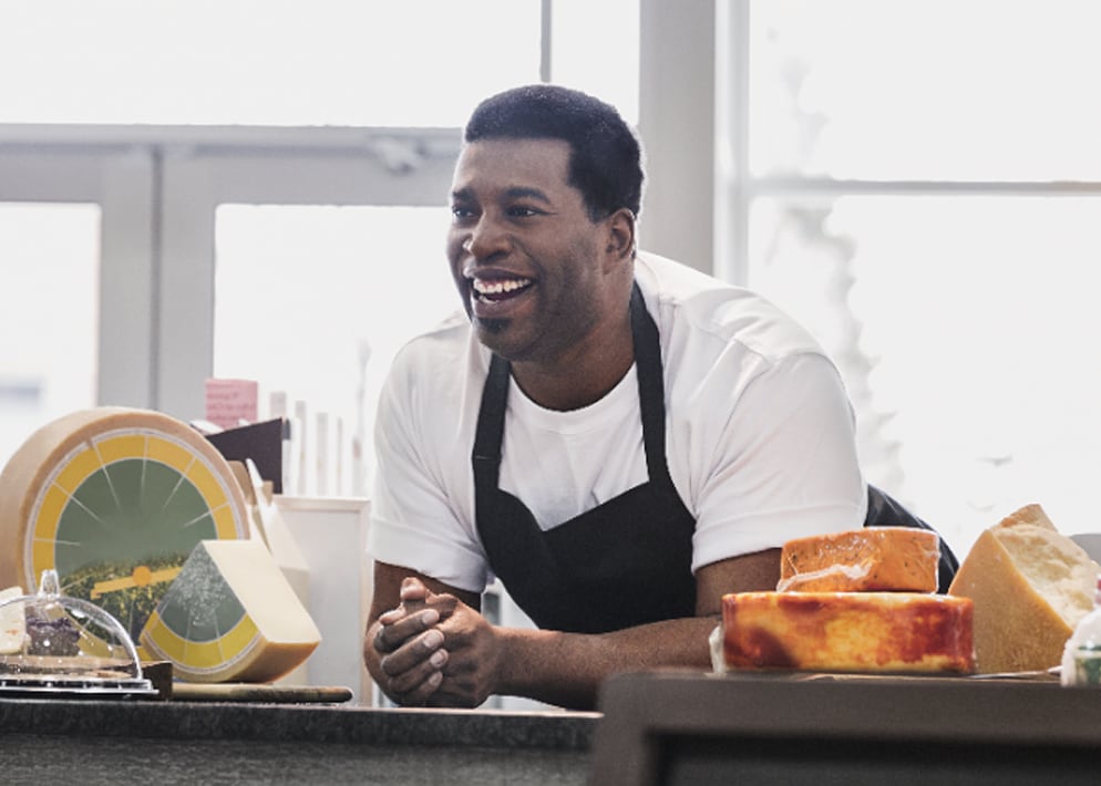 Small business merchant behind counter of cheese shop